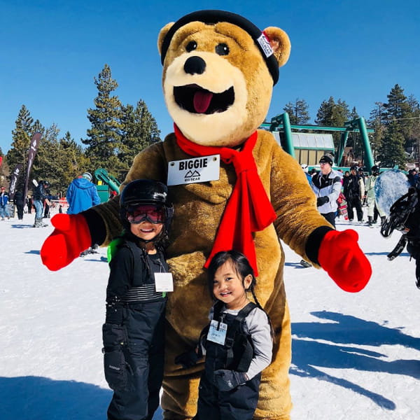 Young children taking a photo with Biggie the mascot